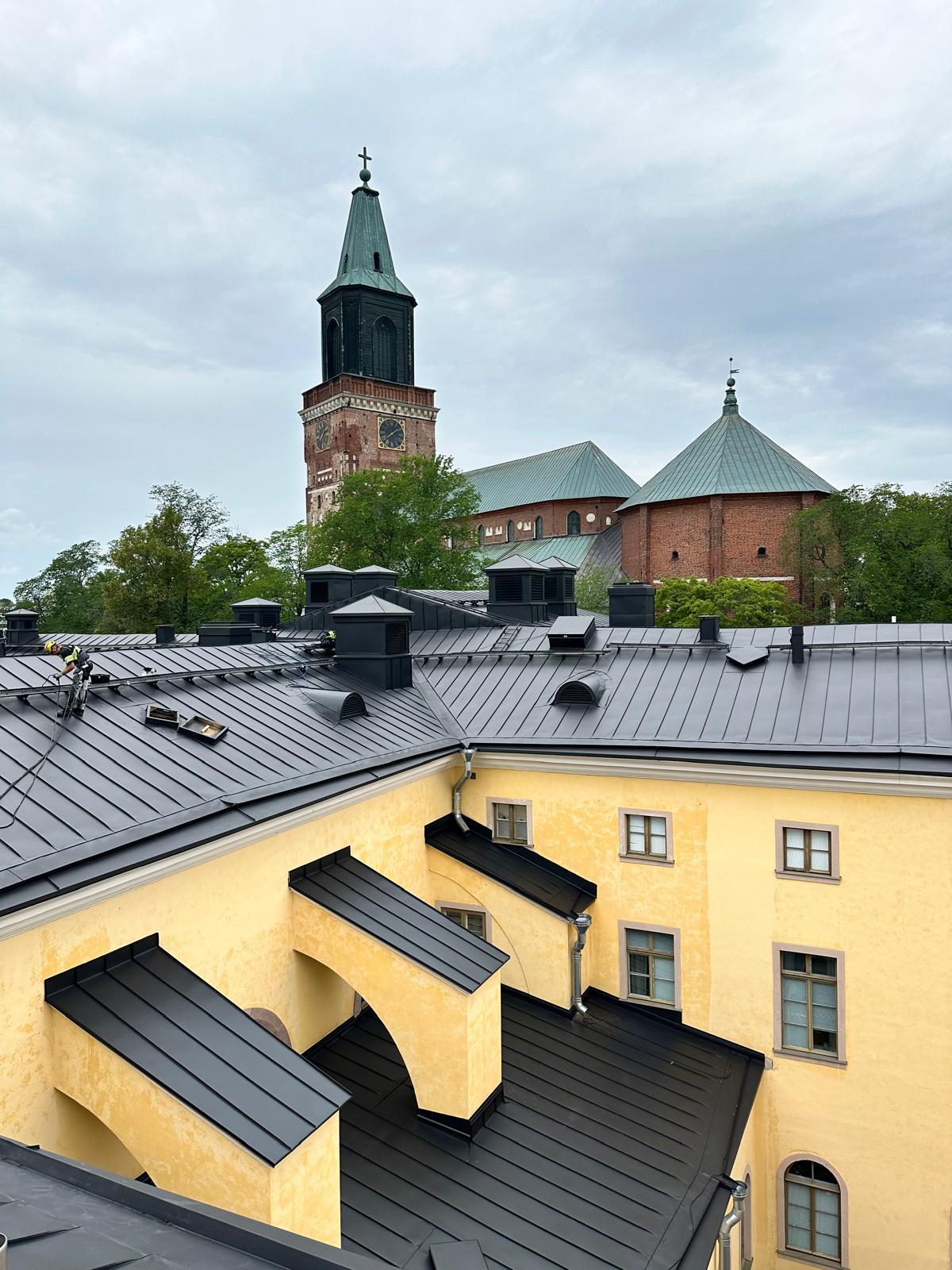 Kattotyö käynnissä mustalla tiilikatolla – Repton Oy